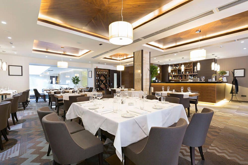 Ein elegantes Restaurant mit eingedeckten Tischen und einer Bar. (Raumluftfilter)