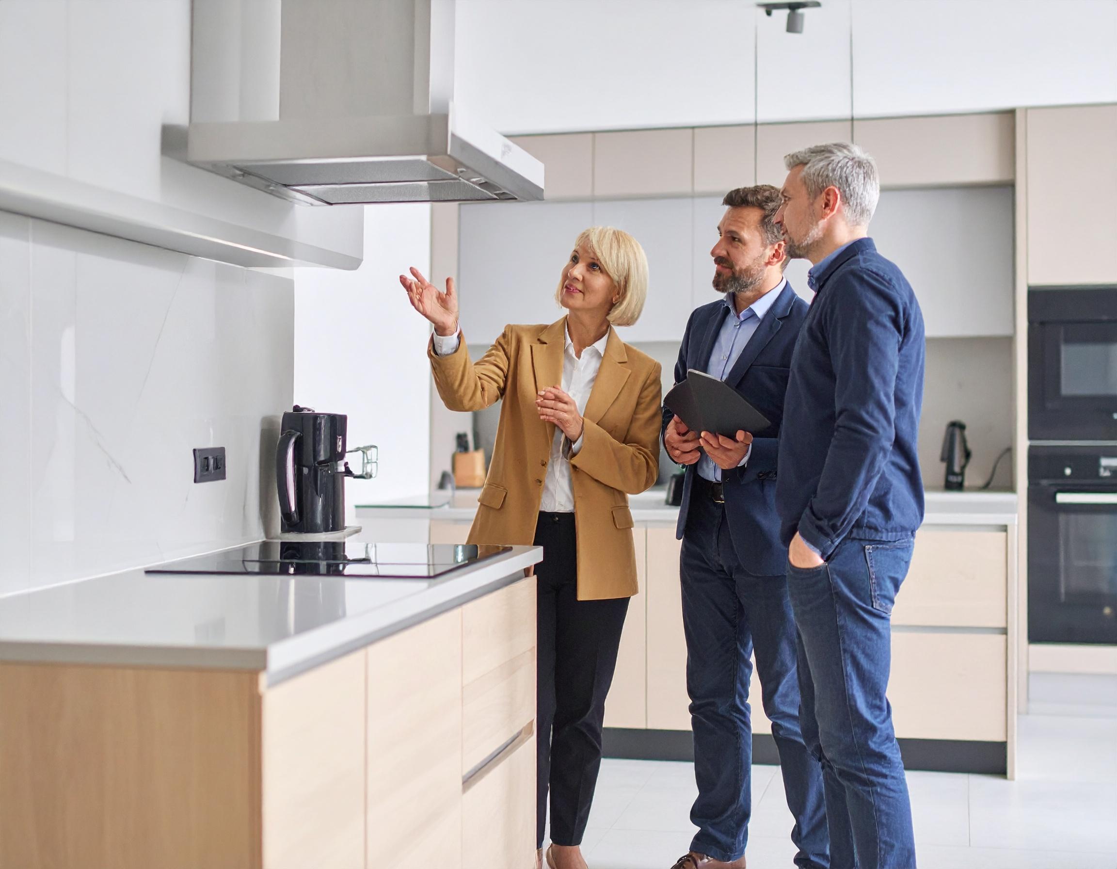 Nachhaltige Luft: Ein paar Menschen werden in einem Küchenstudio um eine Dunstabzugshaube beraten